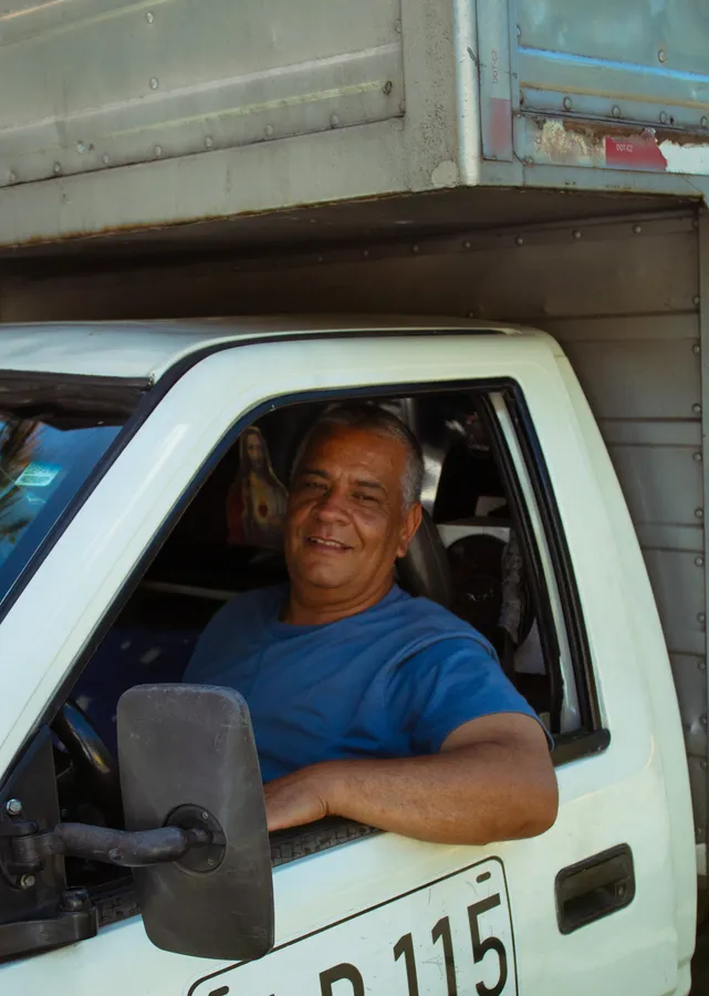 Conductor sonriendo asomado a la ventanilla de su camión