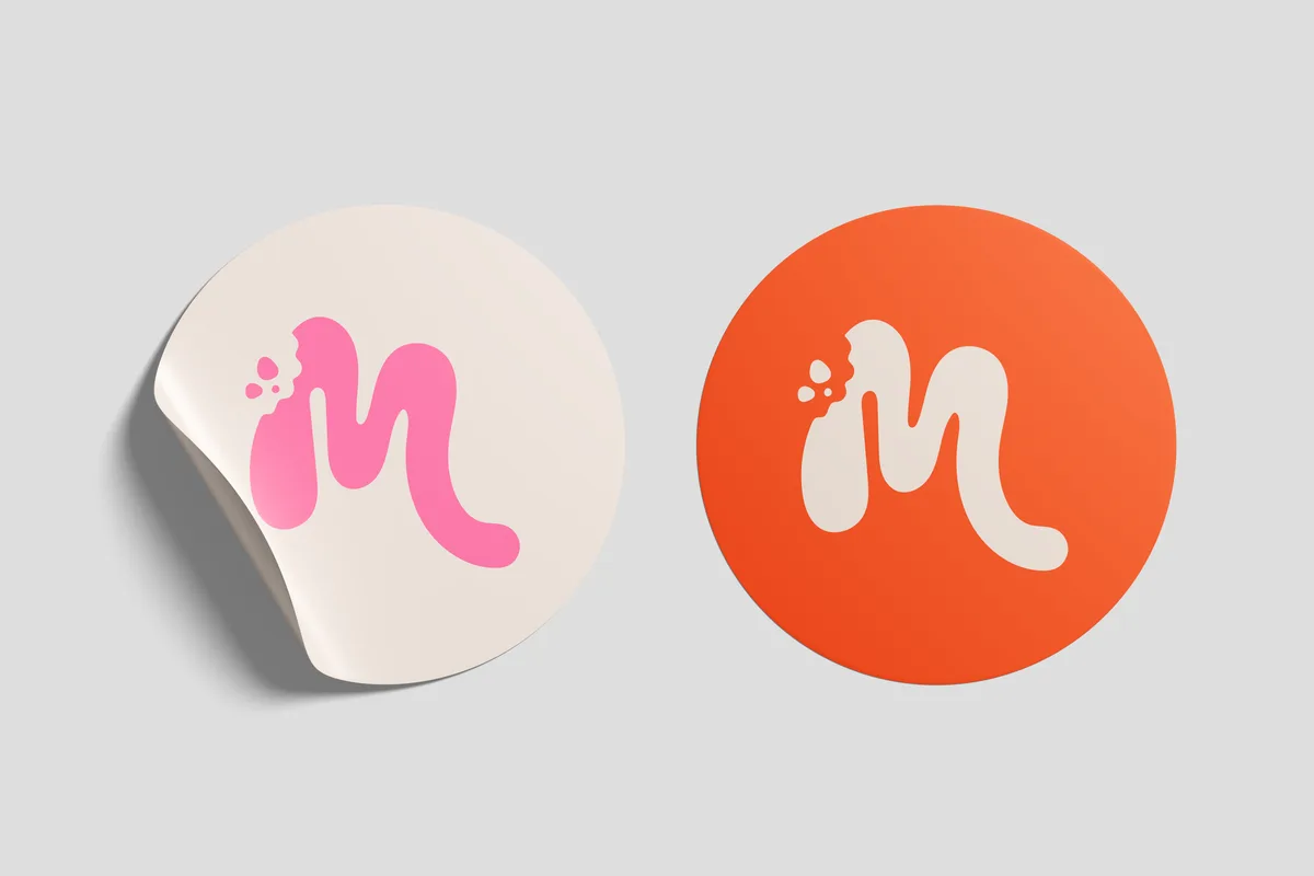 Dos stickers circulares con el isotipo, en crema y en naranja